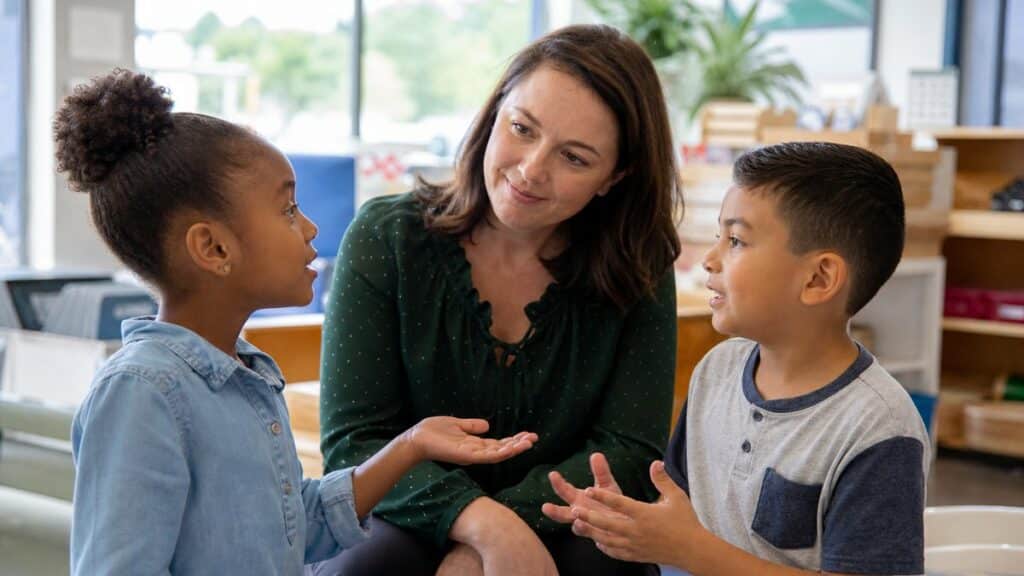Two students in conversation with a teacher, illustrating the interaction hypothesis