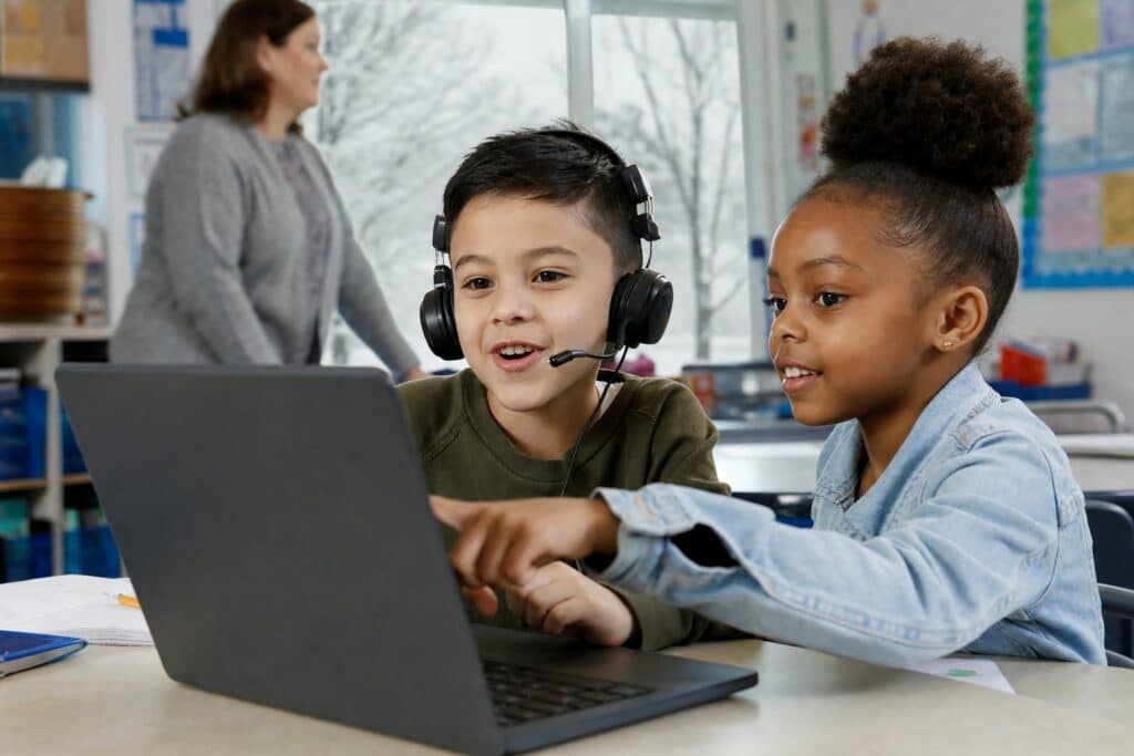 OELPA practice test: two Ohio students practice on a laptop, one answering aloud into a headset microphone